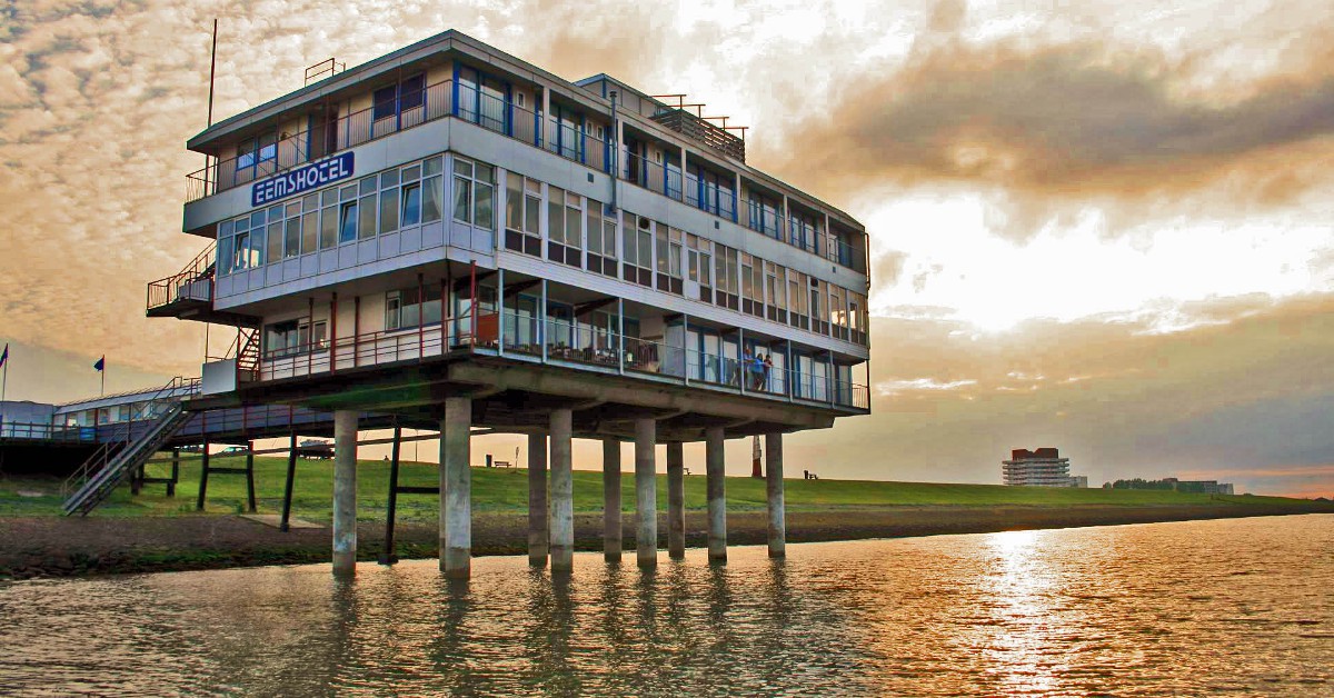 Au-dessus de l'eau aux Pays-Bas Le Eems Hotel au Pays-Bas est installé sur une jetée au-dessus de l l, retenu simplement par quelques pilotis. Le bruit des vagues et les embruns ajoutent une bonne dose de poésie à ce lieu au charme désuet mais bien palpable car l'établissement a été construit dans les années 60.