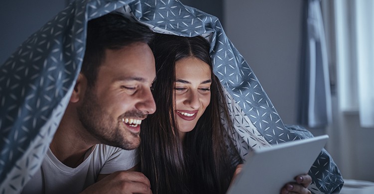 Couple en train de regarder un film sous la couette (Istock)
