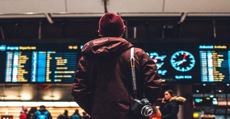 homme regardant le panneau d'affichage d'un aéroport