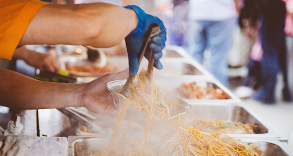 Une barquette de nouilles servie à un stand de streetfood